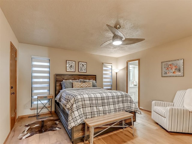 3100 N Eagle Ln, Bethany, OK 73008 - bedroom with light wood-style floors, a textured ceiling, ceiling fan, and connected bathroom