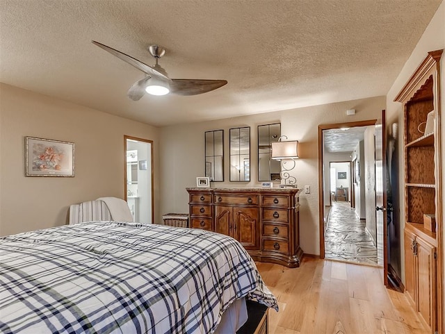 3100 N Eagle Ln, Bethany, OK 73008 - bedroom with light wood-style floors, a textured ceiling, ceiling fan, and connected bathroom