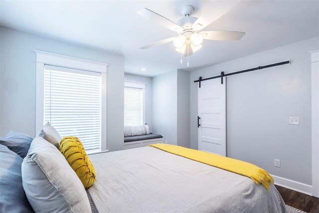1218 N Brookline Ave, Oklahoma City, OK 73107 - bedroom featuring a barn door, wood finished floors, and a ceiling fan