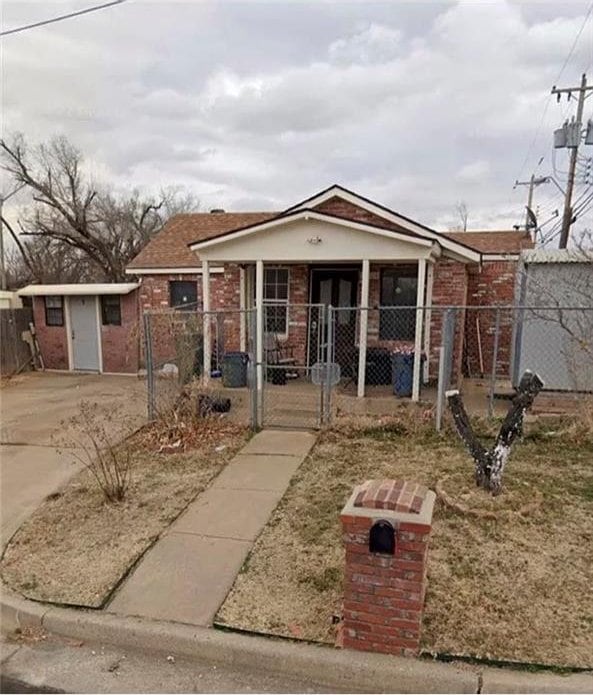 2904 S Indiana Ave, Oklahoma City, OK 73108 - view of front facade with a gate, brick siding, a fenced front yard, and driveway