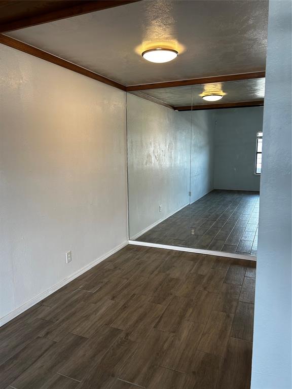 11130 Stratford Dr Unit 418, Oklahoma City, OK 73120 - unfurnished room with dark wood-style floors and baseboards