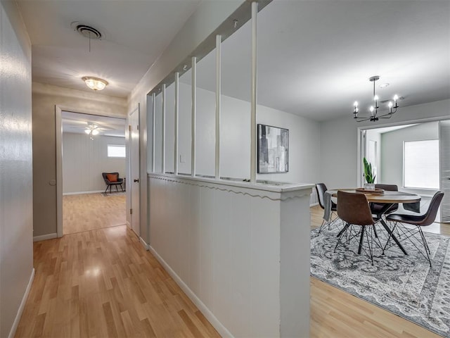 5936 N Ione Dr, Oklahoma City, OK 73122 - corridor with light wood-type flooring and a chandelier