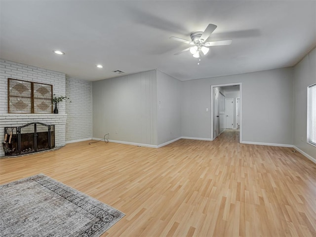 5936 N Ione Dr, Oklahoma City, OK 73122 - unfurnished living room with wood finished floors, ceiling fan, a brick fireplace, recessed lighting, and brick wall