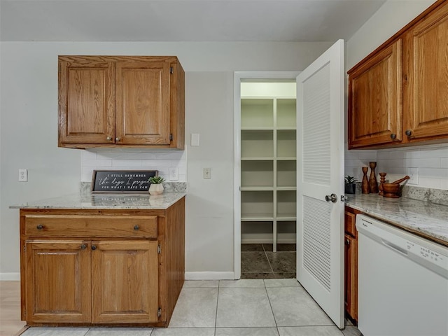 5936 N Ione Dr, Oklahoma City, OK 73122 - kitchen featuring dishwasher, tasteful backsplash, light stone countertops, and brown cabinetry