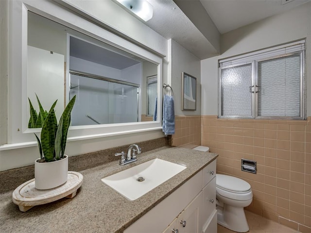 5936 N Ione Dr, Oklahoma City, OK 73122 - full bathroom featuring vanity, a shower with door, wainscoting, and tile walls