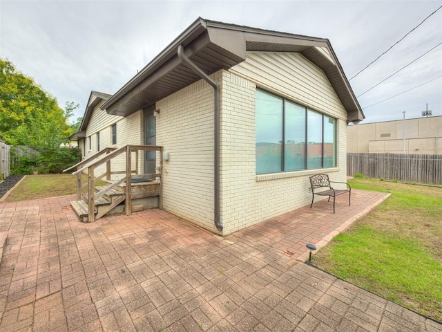 5936 N Ione Dr, Oklahoma City, OK 73122 - view of home's exterior with a fenced backyard, brick siding, and a patio area