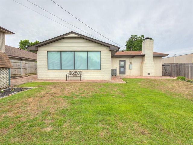 5936 N Ione Dr, Oklahoma City, OK 73122 - rear view of house with brick siding, a fenced backyard, a chimney, and a patio area
