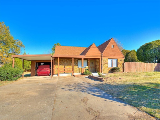 5905 NW 50th St, Oklahoma City, OK 73122 - view of front of house featuring stone siding, driveway, an attached carport, and covered porch