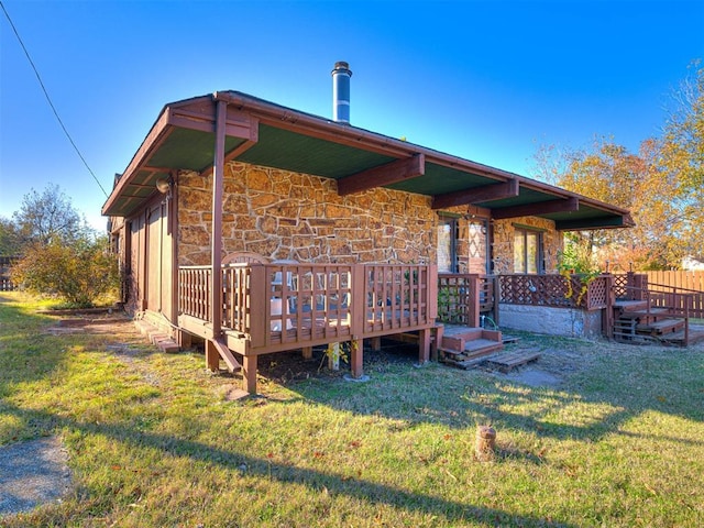 5905 NW 50th St, Oklahoma City, OK 73122 - rear view of property with stone siding, a lawn, and a deck