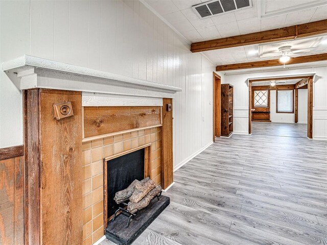 5905 NW 50th St, Oklahoma City, OK 73122 - unfurnished living room featuring wood finished floors, a tile fireplace, beamed ceiling, wood walls, and crown molding