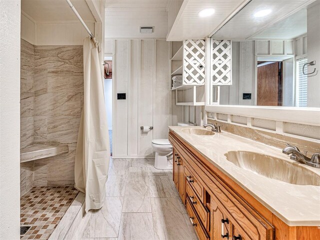 5905 NW 50th St, Oklahoma City, OK 73122 - bathroom featuring tiled shower, double vanity, and marble look tile flooring