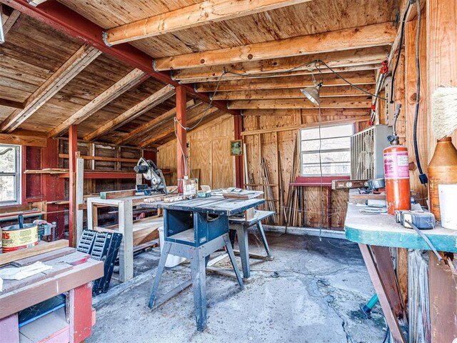 5905 NW 50th St, Oklahoma City, OK 73122 - miscellaneous room featuring a workshop area, vaulted ceiling, wood walls, and concrete flooring