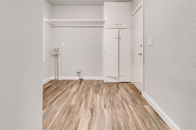 1617 SW 31st St, Oklahoma City, OK 73119 - washroom featuring cabinet space, light wood finished floors, and a textured wall