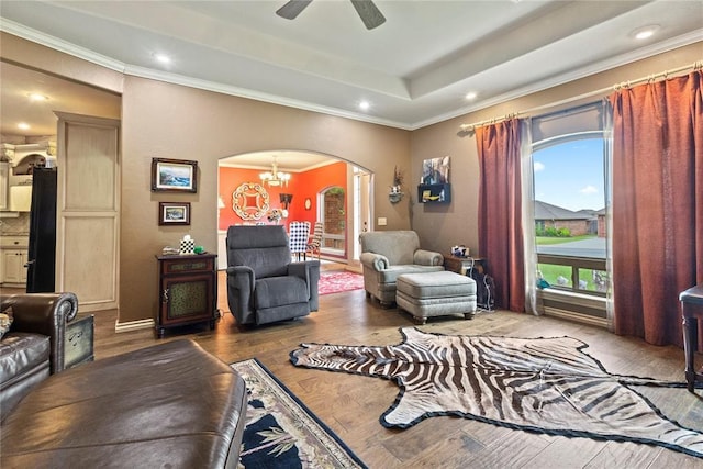 1414 Chisholm Trl, Weatherford, OK 73096 - living area featuring arched walkways, wood finished floors, a chandelier, ornamental molding, and a raised ceiling