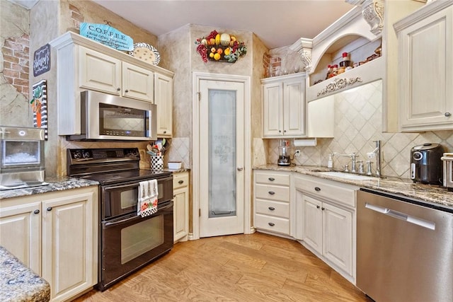 1414 Chisholm Trl, Weatherford, OK 73096 - kitchen featuring appliances with stainless steel finishes, light wood-type flooring, tasteful backsplash, and light stone countertops