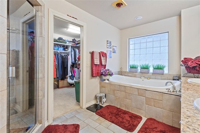 1414 Chisholm Trl, Weatherford, OK 73096 - bathroom with a bath, a shower stall, tile patterned floors, a spacious closet, and vanity