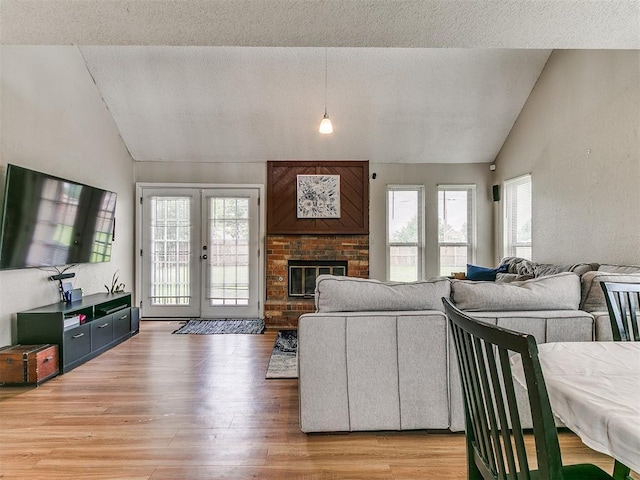 401 NW 120th St, Oklahoma City, OK 73114 - living area with lofted ceiling, light wood-style floors, french doors, a fireplace, and a textured ceiling