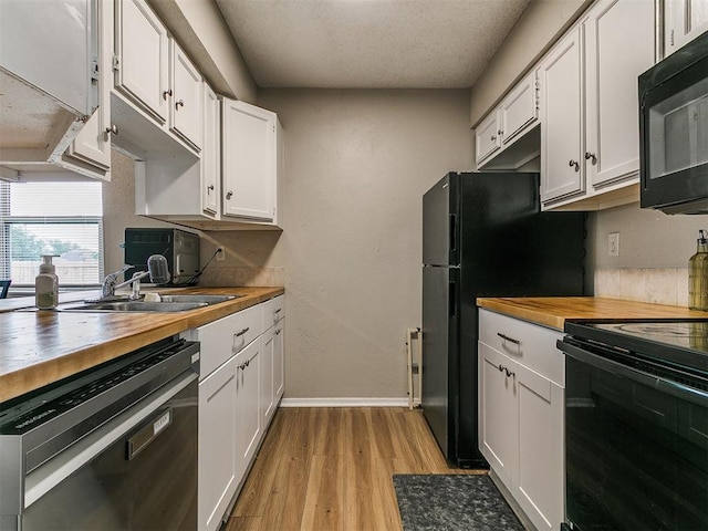 401 NW 120th St, Oklahoma City, OK 73114 - kitchen featuring black appliances, wooden counters, light wood-type flooring, white cabinetry, and a textured ceiling