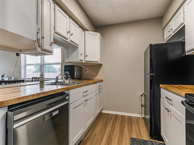 401 NW 120th St, Oklahoma City, OK 73114 - kitchen featuring stainless steel dishwasher, wood counters, light wood-type flooring, white cabinetry, and stove