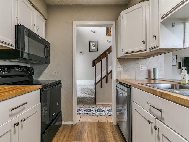 401 NW 120th St, Oklahoma City, OK 73114 - kitchen with black appliances, white cabinetry, butcher block countertops, and wood finished floors