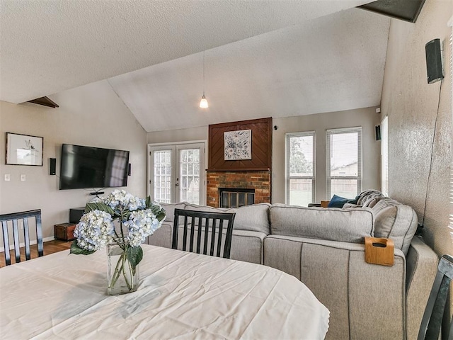 401 NW 120th St, Oklahoma City, OK 73114 - dining area featuring vaulted ceiling, a textured ceiling, a brick fireplace, and wood finished floors