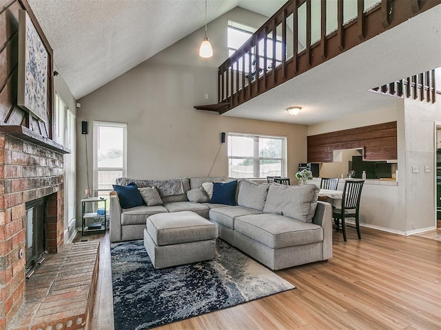 401 NW 120th St, Oklahoma City, OK 73114 - living room with wood finished floors, a brick fireplace, a textured ceiling, and high vaulted ceiling