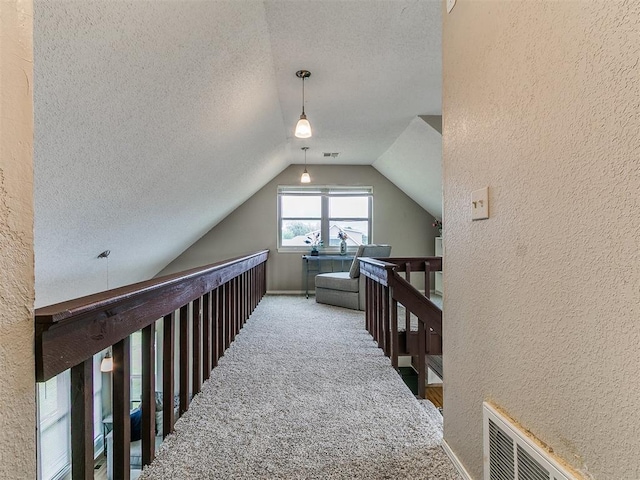 401 NW 120th St, Oklahoma City, OK 73114 - hall featuring a textured wall, a textured ceiling, carpet flooring, lofted ceiling, and an upstairs landing