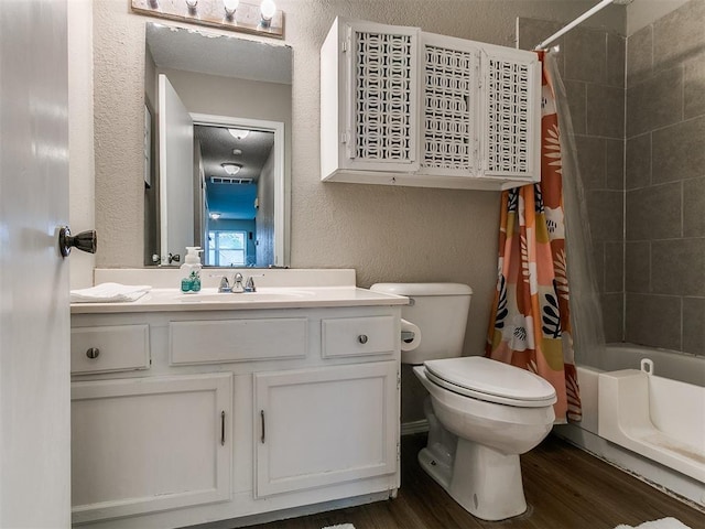401 NW 120th St, Oklahoma City, OK 73114 - bathroom featuring a textured wall, vanity, wood finished floors, and shower / tub combo