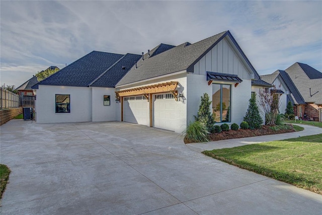 2006 Ithaca Dr, Norman, OK 73071 - modern inspired farmhouse featuring a garage, concrete driveway, board and batten siding, a shingled roof, and a front yard
