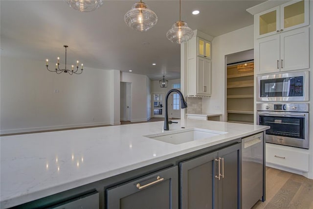 2006 Ithaca Dr, Norman, OK 73071 - kitchen with stainless steel appliances, light wood finished floors, recessed lighting, hanging light fixtures, and white cabinetry