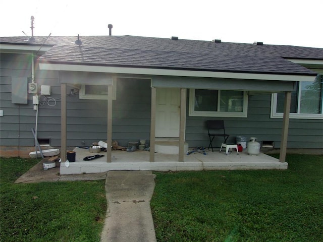 3018 N Beard Ave, Shawnee, OK 74804 - rear view of house featuring roof with shingles, a lawn, and a patio area