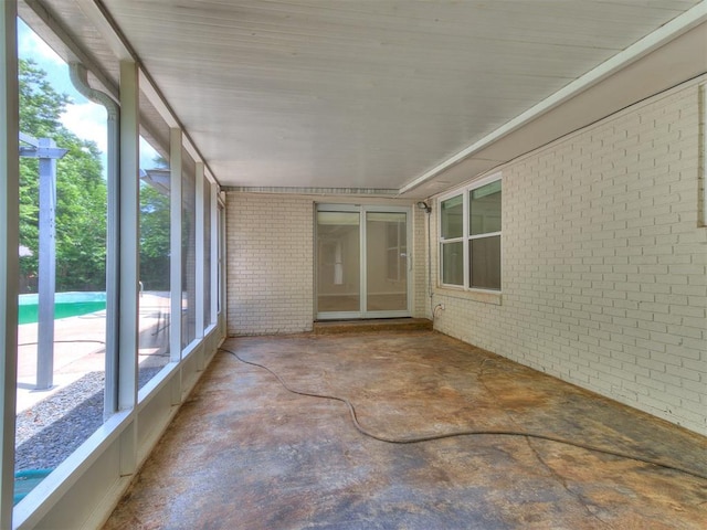 2317 NW 119th St, Oklahoma City, OK 73120 - unfurnished sunroom featuring brick wall and concrete flooring