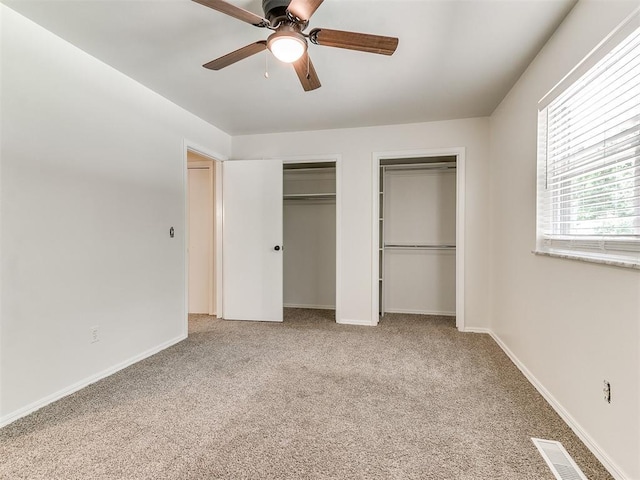 2317 NW 119th St, Oklahoma City, OK 73120 - unfurnished bedroom featuring two closets, carpet flooring, and a ceiling fan