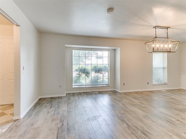 2317 NW 119th St, Oklahoma City, OK 73120 - unfurnished room featuring light wood-style floors, a chandelier, and a smoke detector