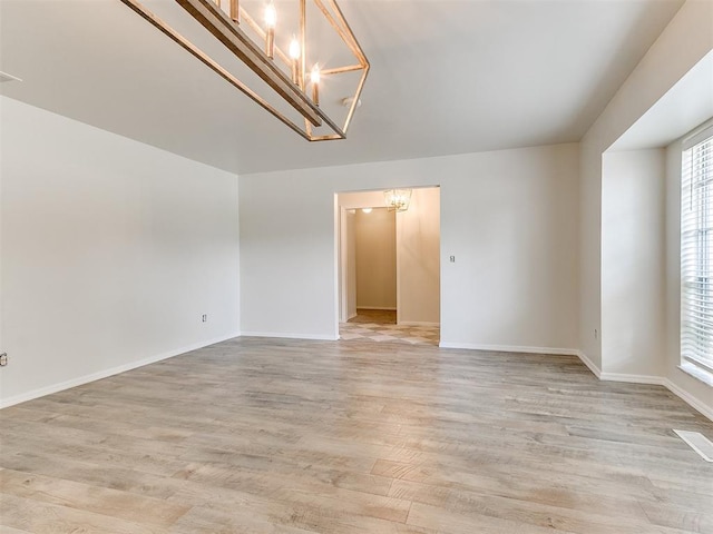 2317 NW 119th St, Oklahoma City, OK 73120 - empty room featuring a chandelier and light wood finished floors