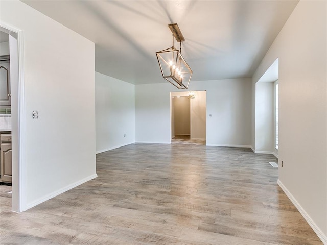 2317 NW 119th St, Oklahoma City, OK 73120 - unfurnished dining area featuring light wood finished floors and a chandelier