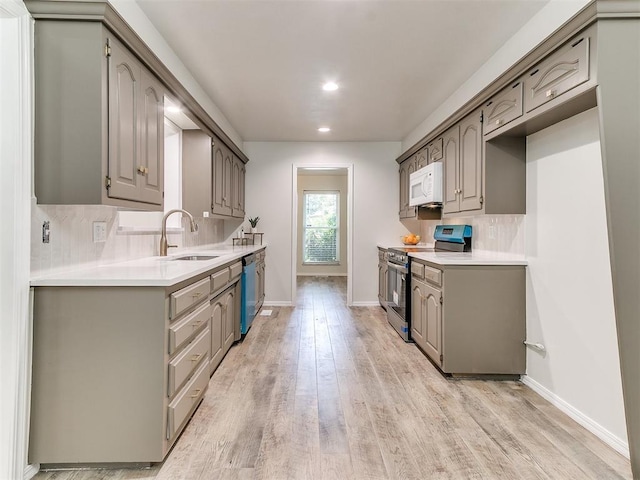 2317 NW 119th St, Oklahoma City, OK 73120 - kitchen featuring appliances with stainless steel finishes, light wood-type flooring, backsplash, light countertops, and recessed lighting
