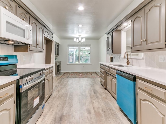 2317 NW 119th St, Oklahoma City, OK 73120 - kitchen with stainless steel electric stove, dishwashing machine, white microwave, a chandelier, and tasteful backsplash