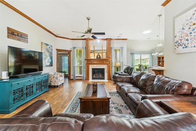 12409 Gaylon Cir, Oklahoma City, OK 73170 - living area featuring wood finished floors, ceiling fan, a fireplace, a chandelier, and ornamental molding