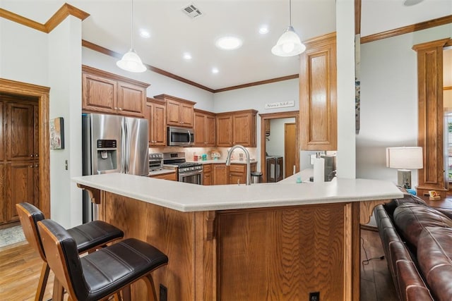 12409 Gaylon Cir, Oklahoma City, OK 73170 - kitchen featuring appliances with stainless steel finishes, a breakfast bar, crown molding, light wood-style floors, and light countertops