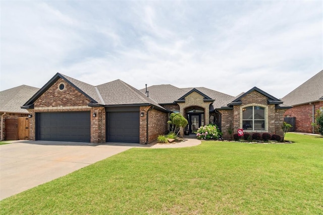 1600 SW 123rd St, Oklahoma City, OK 73170 - french provincial home featuring a garage, brick siding, a front yard, driveway, and roof with shingles