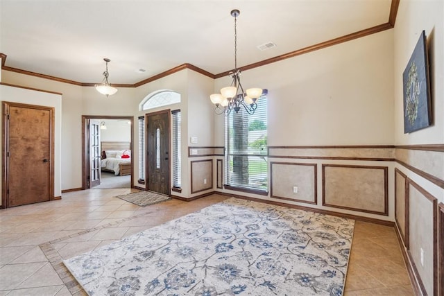 1600 SW 123rd St, Oklahoma City, OK 73170 - foyer featuring light tile patterned floors, crown molding, a chandelier, a wainscoted wall, and a decorative wall