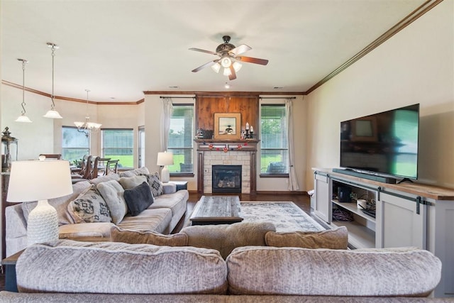 1600 SW 123rd St, Oklahoma City, OK 73170 - living room with a ceiling fan, a chandelier, crown molding, a stone fireplace, and wood finished floors