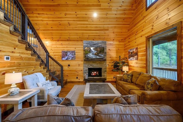 64 Mountain Alder Trl, Broken Bow, OK 74728 - living room with healthy amount of natural light, wood walls, wood finished floors, a fireplace, and stairway