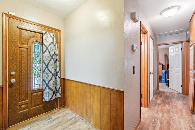 3414 Clayton Dr, Tuttle, OK 73089 - foyer entrance with light wood-type flooring, a textured wall, wood walls, and wainscoting