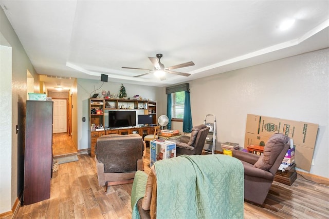 3414 Clayton Dr, Tuttle, OK 73089 - living room featuring a ceiling fan, light wood finished floors, and a raised ceiling