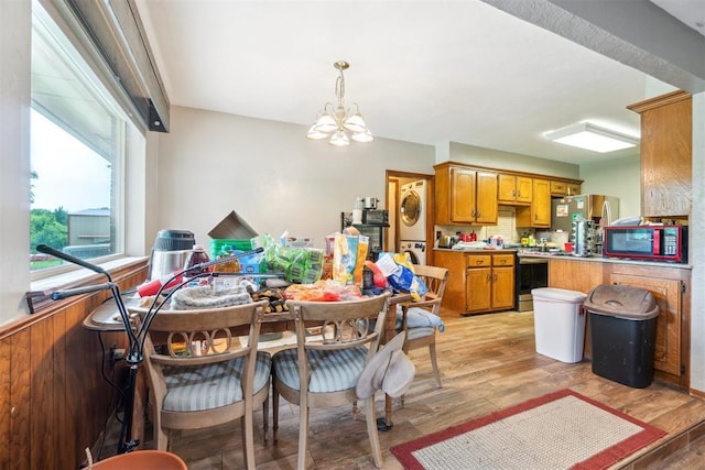 3414 Clayton Dr, Tuttle, OK 73089 - dining space featuring stacked washer and clothes dryer, a chandelier, and light wood-style floors