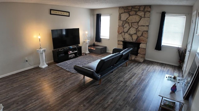 2628 N Ann Arbor Ave Unit 102, Oklahoma City, OK 73127 - living room featuring a stone fireplace, plenty of natural light, wood finished floors, and a textured ceiling