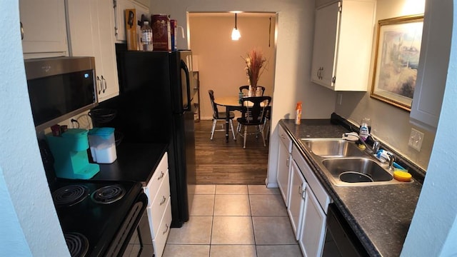 2628 N Ann Arbor Ave Unit 102, Oklahoma City, OK 73127 - kitchen with stainless steel microwave, dark countertops, white cabinets, black range with electric cooktop, and dishwasher