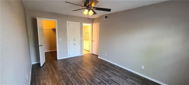 2628 N Ann Arbor Ave Unit 102, Oklahoma City, OK 73127 - unfurnished bedroom featuring dark wood-style floors, a closet, a walk in closet, and a ceiling fan
